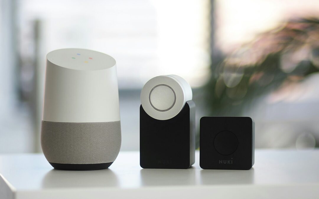 white and gray Google smart speaker and wo black speakers